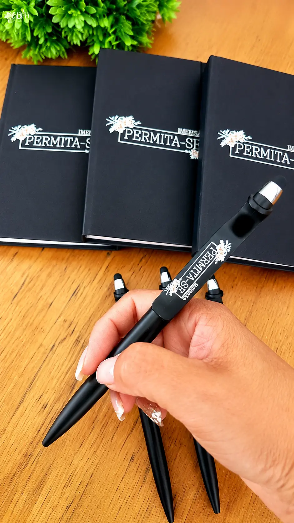 Cadernos e canetas pretos personalizados com a identidade de um evento