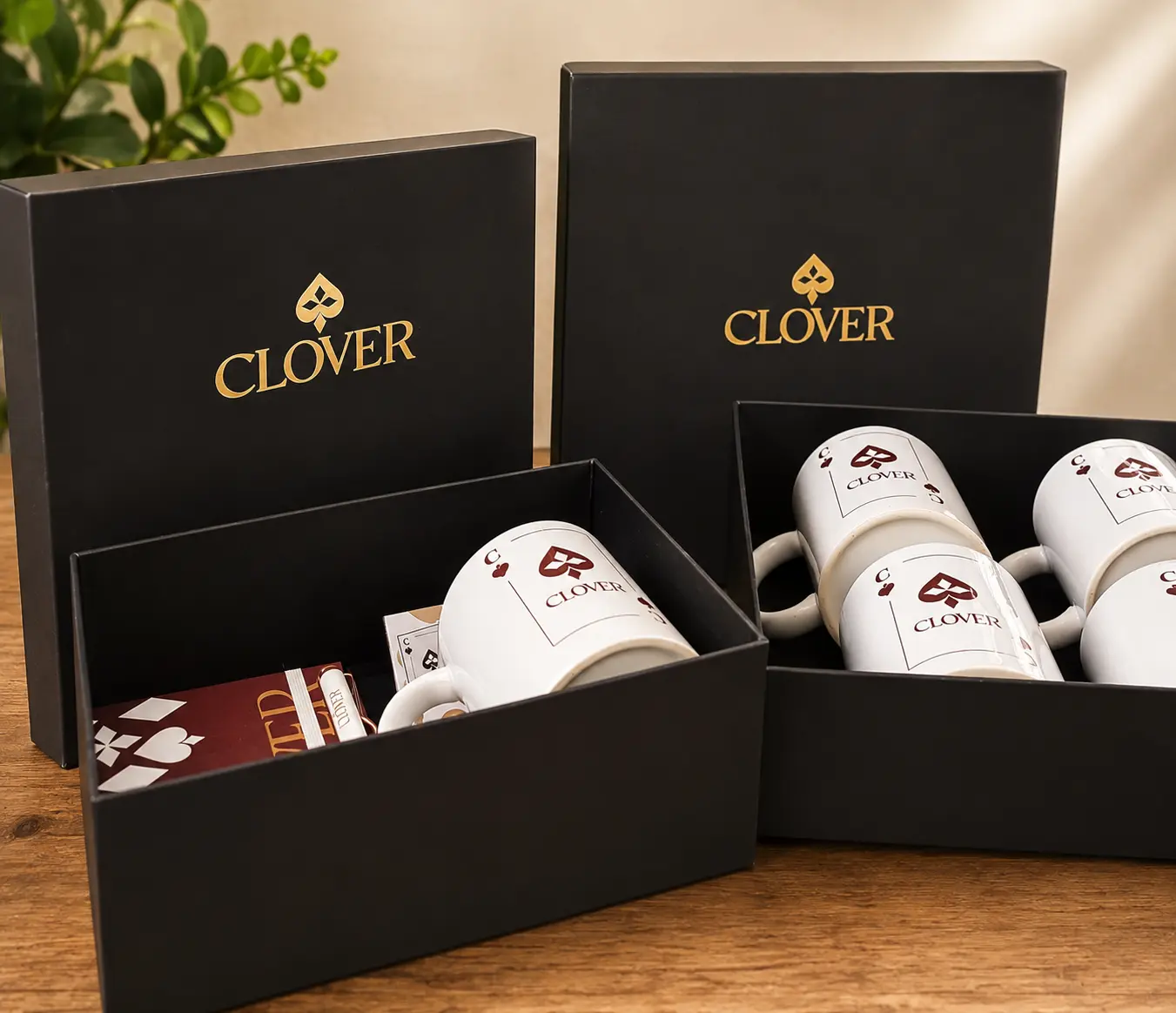 Caixas pretas personalizadas com logo dourada na tampa e canecas com a marca do cliente